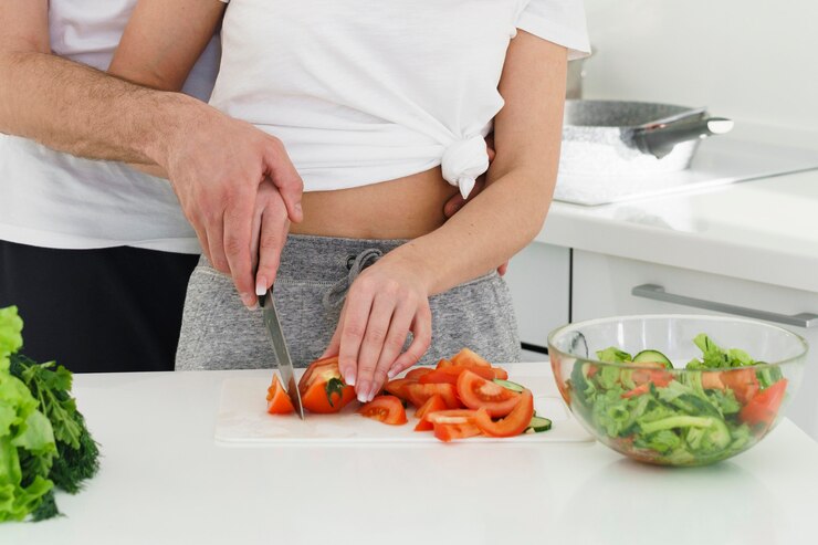 couple-cutting-vegetables_23-2148535201